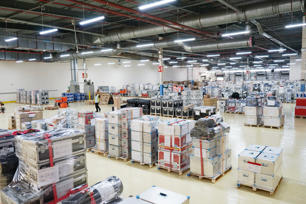 An areal photo of a warehouse, with various boxes and flight cases stored in rows.